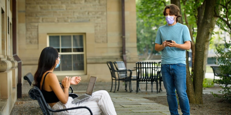Bryan Maley, right, a Cornell University grad student in the Master of Public Health program, interviews a student on campus about mask-wearing experiences as part of a public health survey at the school on July 30. 