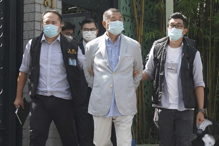 Image: Hong Kong media tycoon Jimmy Lai, center, who founded local newspaper Apple Daily, is arrested by police officers at his home in Hong Kong