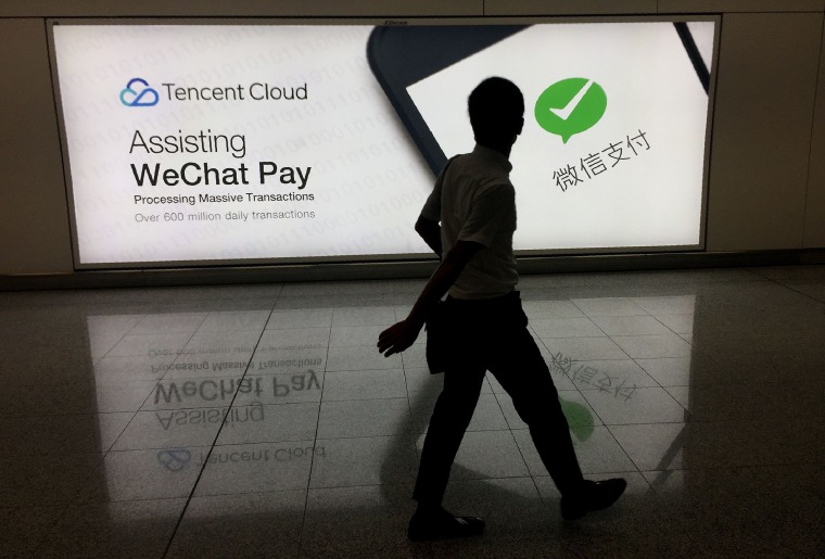 A man walks past an advertisement for the social media platform WeChat in Hong Kong's international airport on Aug. 21, 2017.