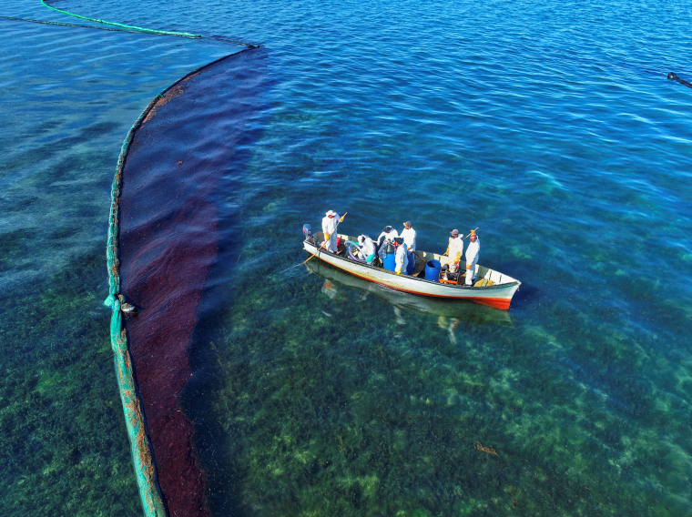Image: Fishermen on a boat as they volunteer near the area where the bulk carrier ship MV Wakashio ran aground on a reef, at Riviere des Creoles, Mauritius