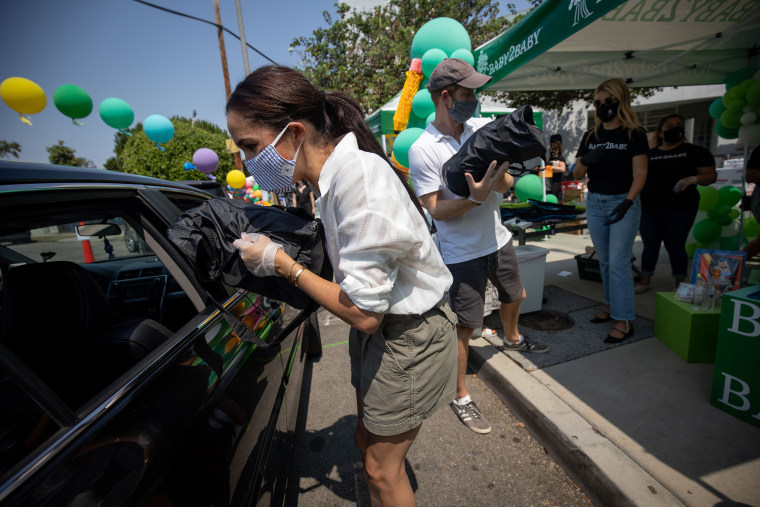 The duke and duchess wore masks and gloves as they handed out essential school supplies.