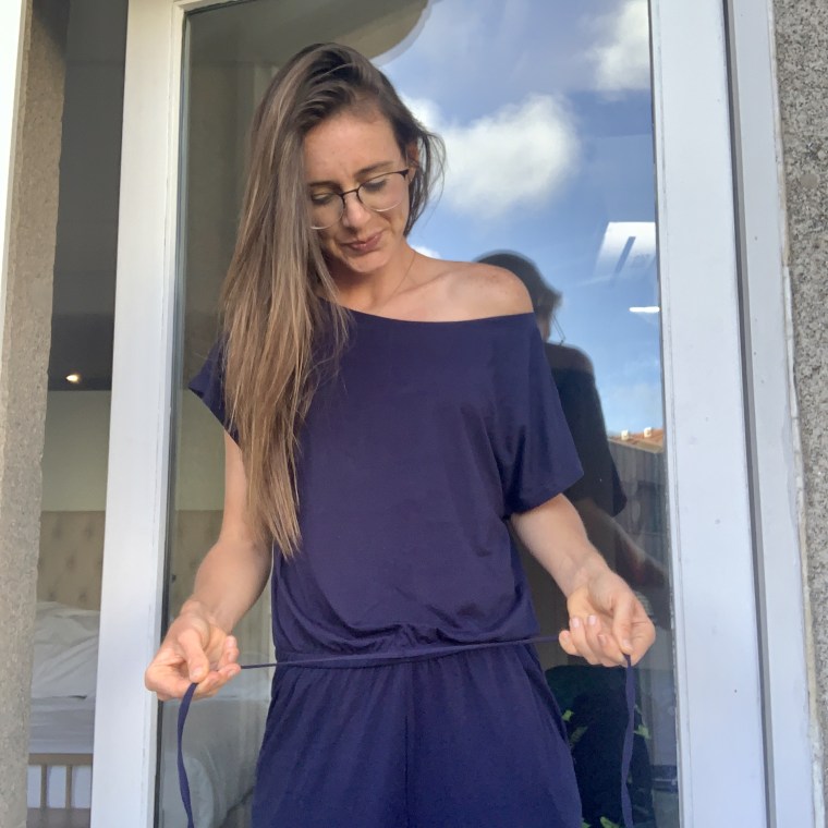 Katie Jackson adjusting the drawstring on her off-shoulder jumpsuit
