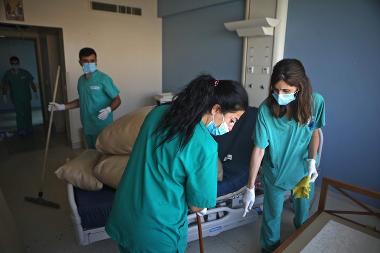 Image: Nurses from the Saint George hospital clean one of the damaged rooms in Beirut's neighbourhood of Ashrafieh