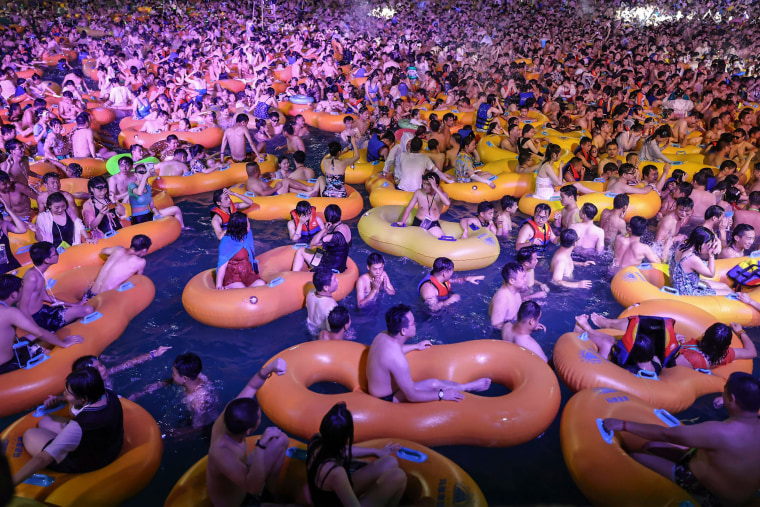 Image: People watching a performance as they cool off in a swimming pool in Wuhan in China's central Hubei province on Aug. 15, 2020