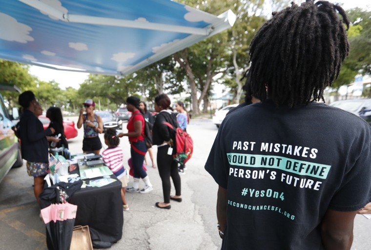 People gather around a Ben & Jerry's "Yes on 4" truck as they learn about Amendment 4, which would restore voting eligibility to 1.4 million returning citizens in Florida, in Miami on October 2018.