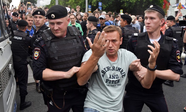 Image: Opposition leader Alexei Navalny is detained by Russian police officers during a march to protest in central Moscow