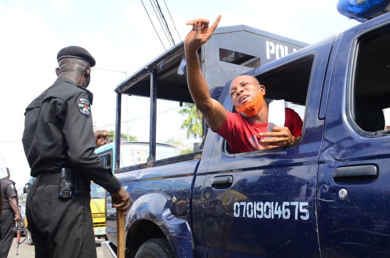 Image: A police man arrests a demonstrator and supporter of the "#Revolution Now" movement in Lagos, Nigeria