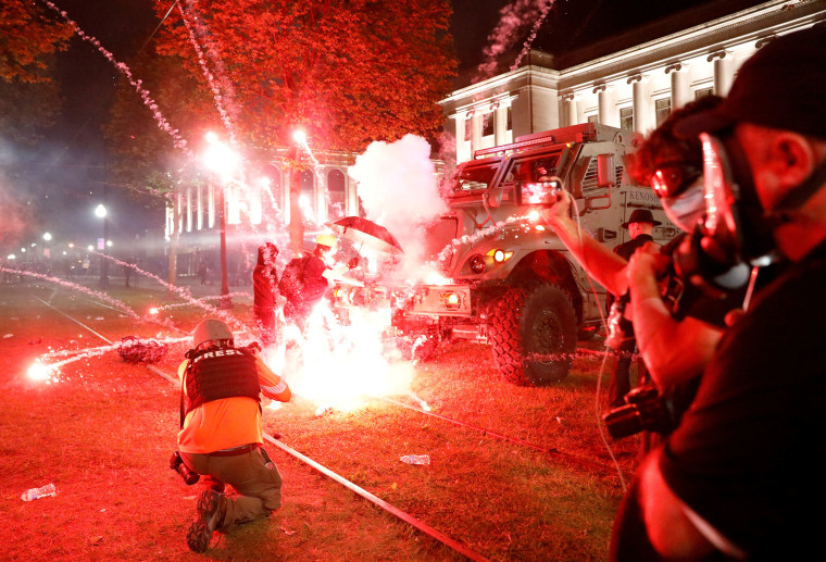 Image: Flares go off in front of a Kenosha Country Sheriff Vehicle as demonstrators take part in a protest following the police shooting of Jacob Blake, a Black man, in Kenosha