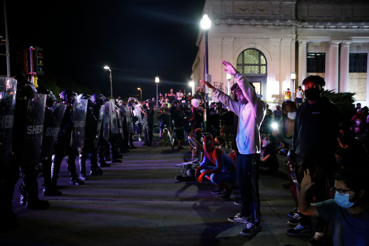 Image: Protestors face off with police outside the County Courthouse during demonstrations against the shooting of Jacob Blake in Kenosha