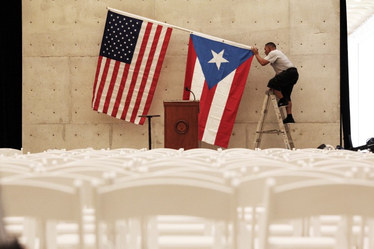 A worker takes off the U.S and Puerto Rican flag after a rally of U.S. Democratic presidential candidate Bernie Sanders in San Juan