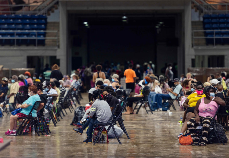 Image: People prepare to board a bus for evacuation before the arrival of hurricane Laura in Lake Charles