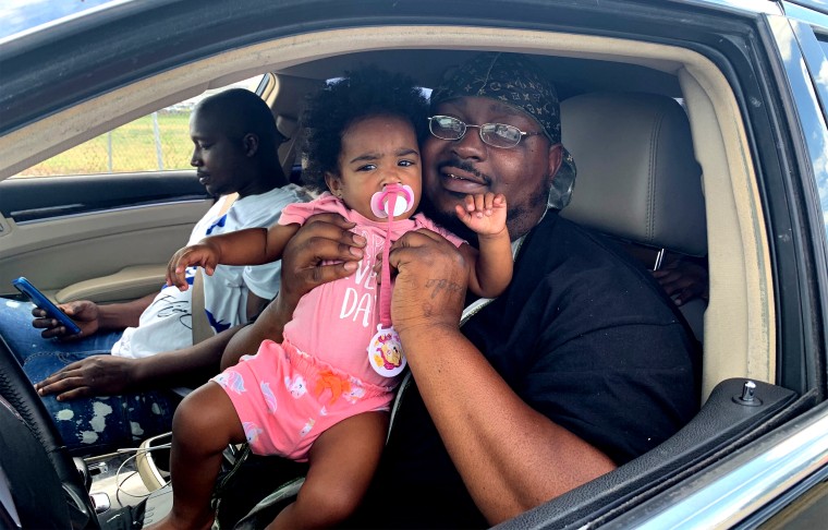 Richard Thomas, 30, of Beaumont, with Maya Matthews, age 1, waited in a line of cars in San Antonio to get assigned hotel rooms where he and his family will wait out Hurricane Laura, on Aug. 26, 2020.