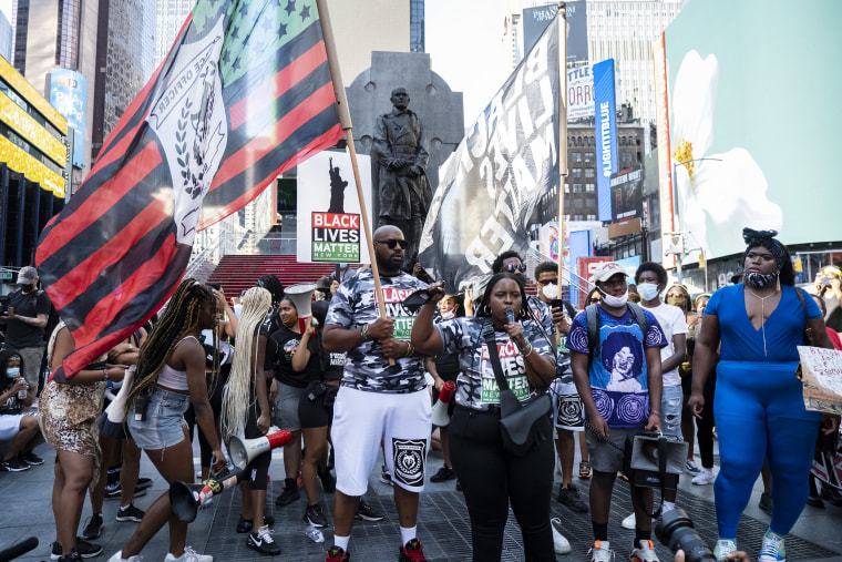 Chivona Renee Newsome, center, addresses the crowd of protesters  in support of Black women in New York's Times Square on July 26, 2020. Joining her is Qween Jean, right, an off-Broadway costume designer and an organizer for Black trans liberation.
