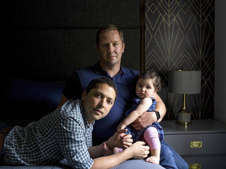 Jonathan Gregg, left, and Derek Mize, with their daughter Simone in Decatur, Ga.