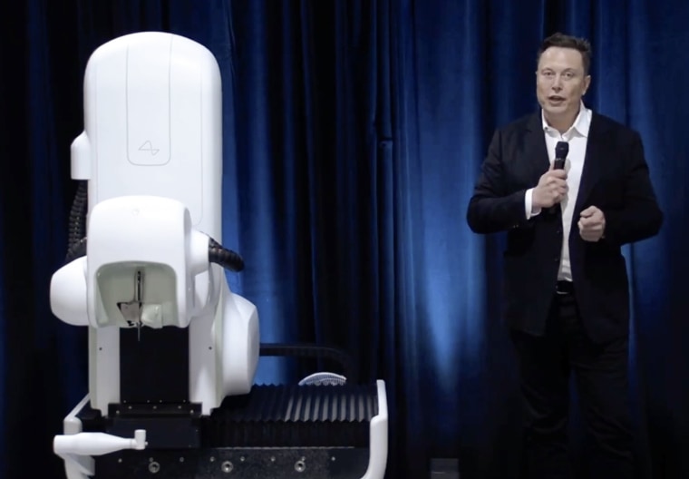 Elon Musk standing next to the surgical robot during his Neuralink presentation on Friday.