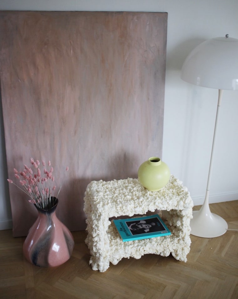 A yellow vase and a teal blue magazine adorn a foam side table from Gustaf Westman.