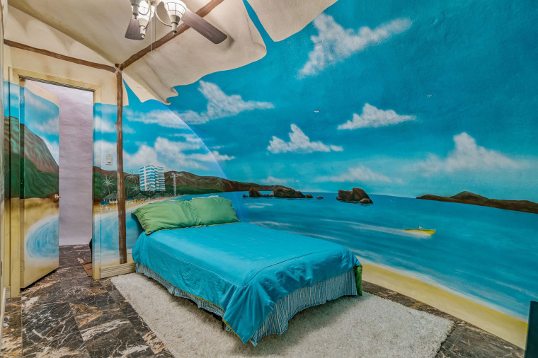 One bedroom features a tropical beach motif with matching teal blue bedding. 