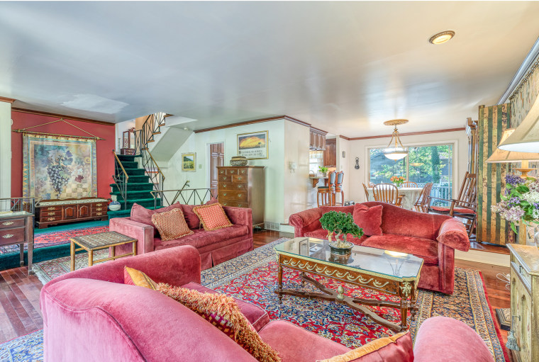 The spacious living room is decorated with red furniture.