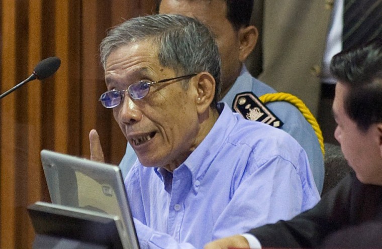 Image: Khmer Rouge commander Kaing Guek Eav, also known as Duch, speaks to his attorneys moments before the start of his trial on the outskirts of Phnom Penh