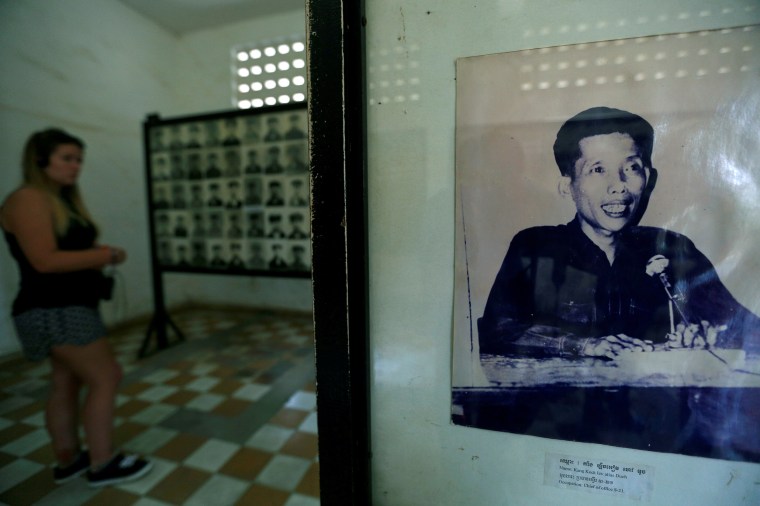 Image: A visitor walks past a picture of Kaing Guek Eav, alias "Duch", a prison commander for the Khmer Rouge regime who died on Sept. 2, at the Tuol Sleng Genocide Museum in Phnom Penh, Cambodia