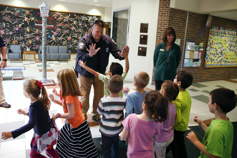 Image: Forest Dale Elementary School principal Deanna Pitman, right, and Carmel Police Officer Greg DeWald welcome back students as they return to class following an intruder drill in Indiana on May 6, 2016.