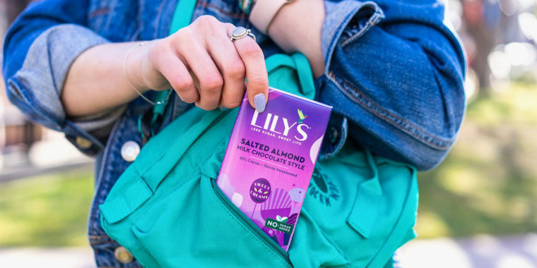 Woman pulling keto chocolate bar out of backpack