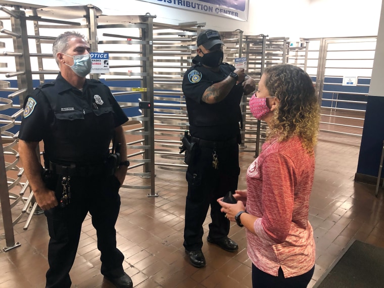 Two U.S. Postal Inspection Service officers block Rep. Debbie Wasserman Schultz, D-Fla., from entering the Miami Processing and Distribution Center in the early morning hours of Sept. 4.