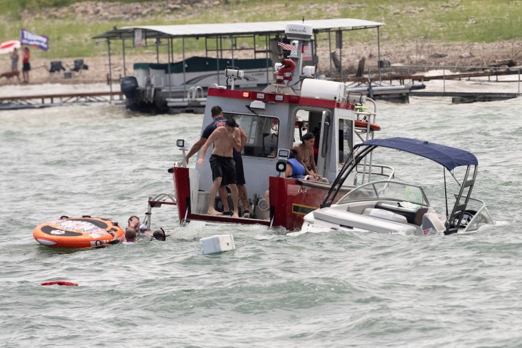 Image: Boats partially submerged from the large wakes of a flotilla of supporters of President Donald Trump