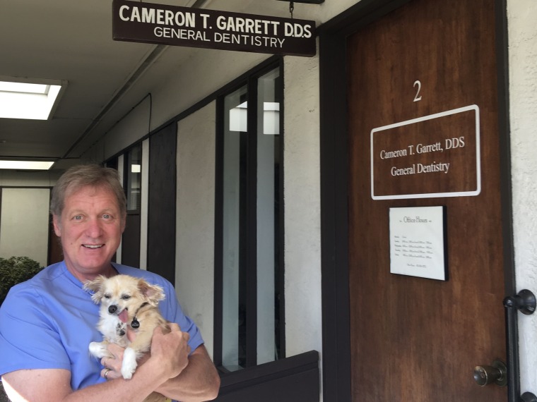 Dr. Cameron Garrett holds Karma, his first dental therapy dog.