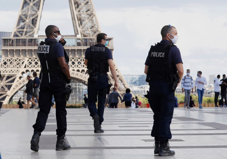 Image: Police officers wearing protective masks patrol in front of the Eiffel Tower as France reinforces mask-wearing as part of efforts to curb a resurgence of the coronavirus disease (COVID-19) across the country, in Paris