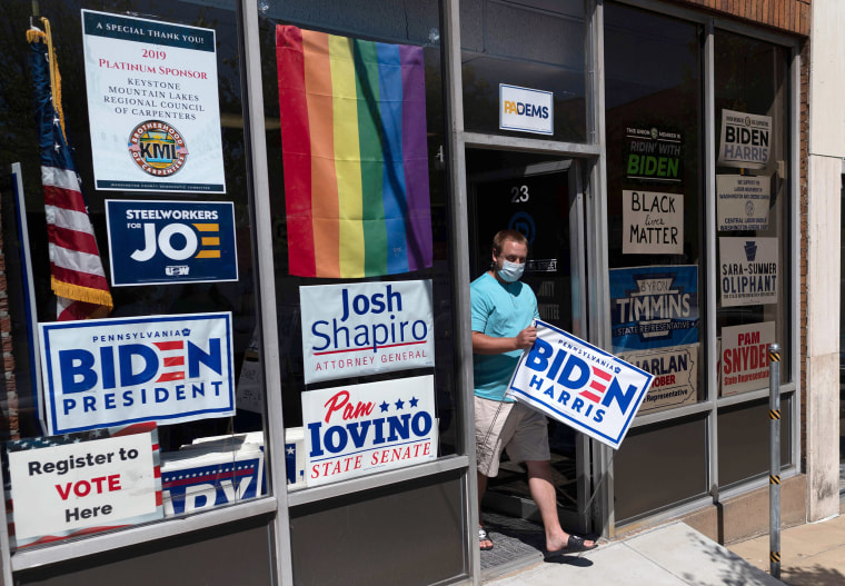 Image: A man walks out of the Washington county Democratic office with a yard sign for Presidential candidate Joe Biden in Canonsburg, Pennsylvania.