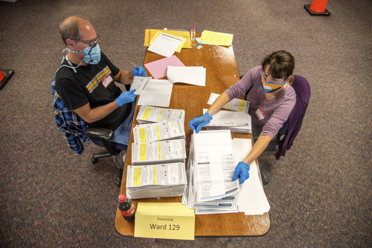 Election workers process absentee ballots at Milwaukee's central count facility on Aug. 11, 2020.