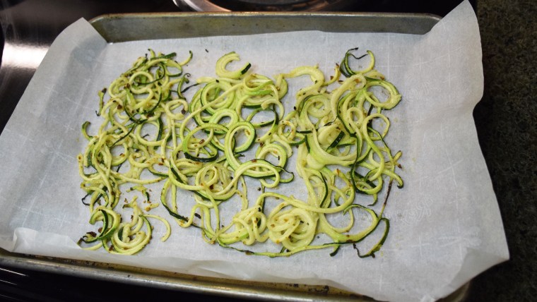 Parchment paper ensures that the zucchini noodles won't stick to the pan.