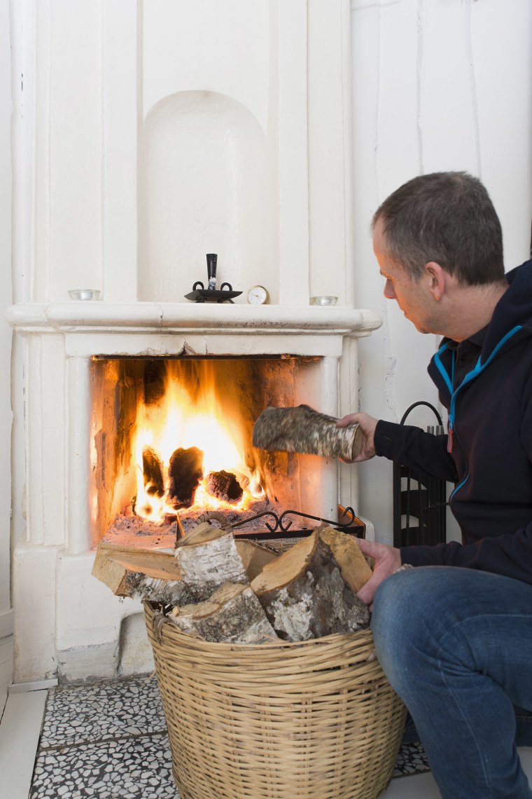 Man putting wood in fireplace