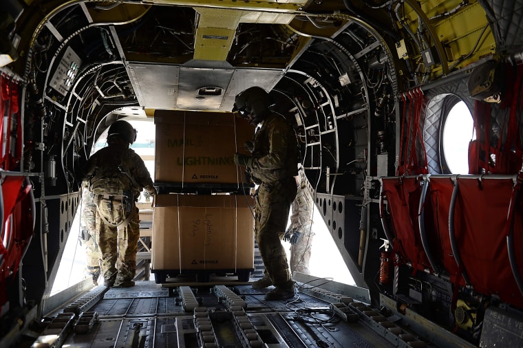 Image: U.S. soldiers, part of the NATO-led International Security Assistance Force (ISAF), loading huge boxes into a Chinook helicopter at Bagram Air Field