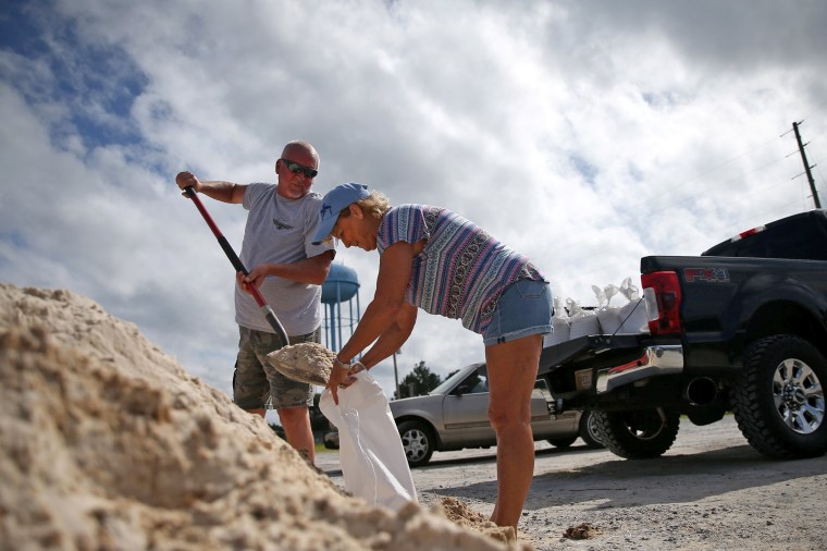 Image: Rodney and Peggy Thomas fill sandbags as Tropical Storm Sally approaches in Bay St. Louis