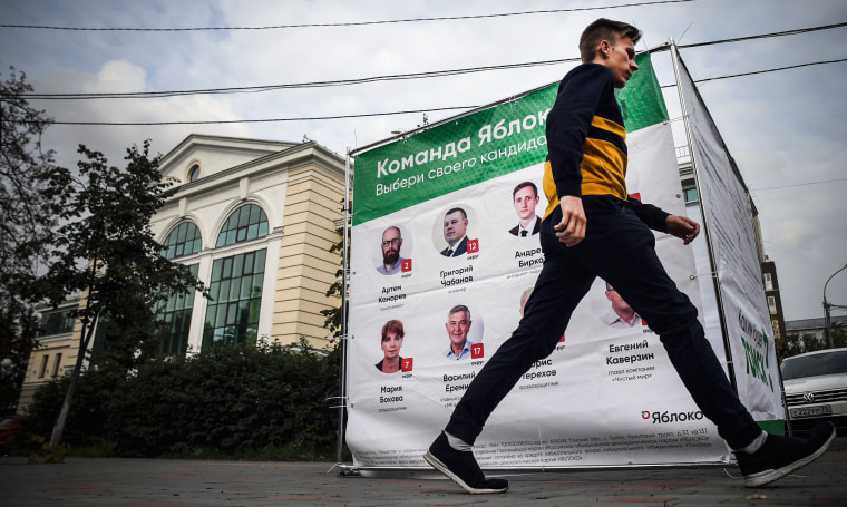 Image: A man walks past an election banner for the Yabloko liberal party in the Siberian city of Tomsk, Russia