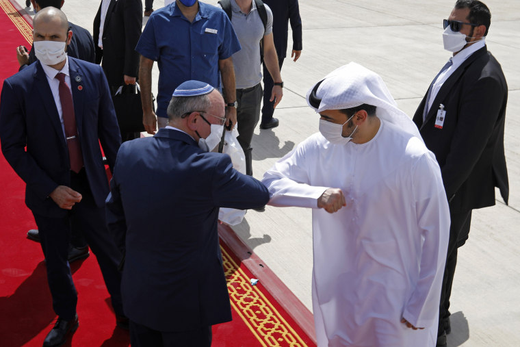 Image: Israeli National Security Advisor Meir Ben-Shabbat, center left, elbow bumps with an Emirati official as he leaves Abu Dhabi, Arab Emirates