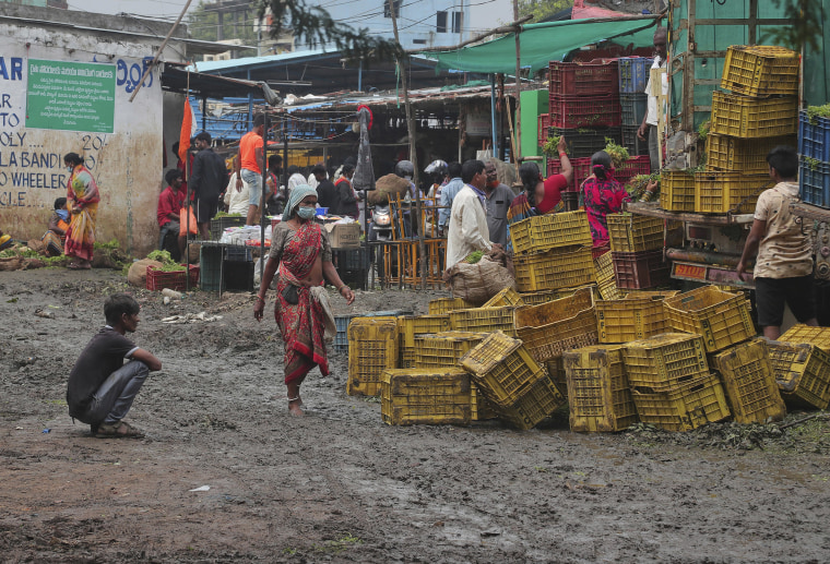 Image: People wearing face masks as a precaution against the coronavirus shop for vegetables at a market in Hyderabad, India