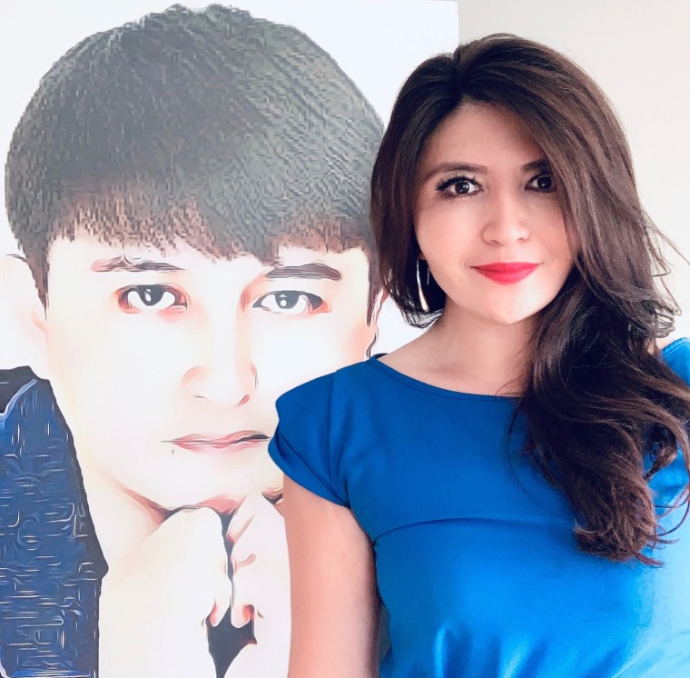Rayhan Asat in front of her brother Ekpar Asat's portrait in September.