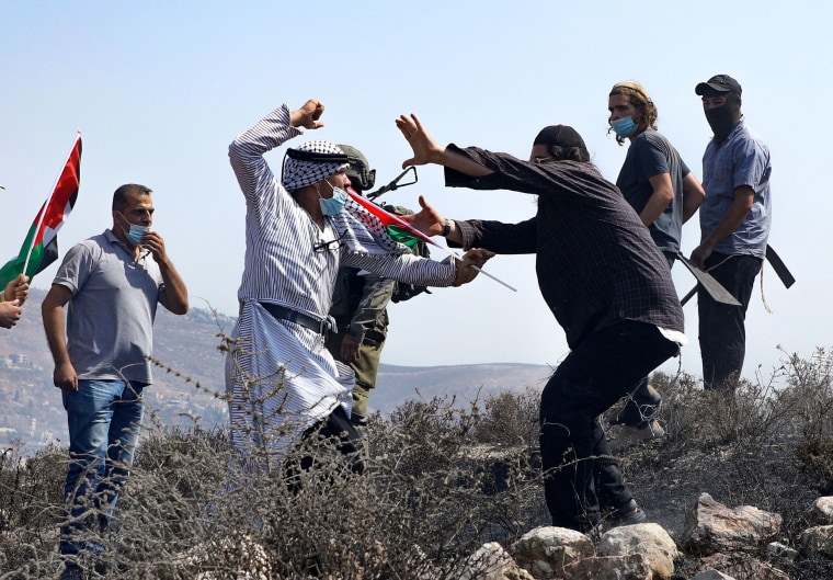 Image: Palestinians protesting against Jewish settlements and the normalisation of ties with two Arab states, scuffle with Israeli settlers in Asira al-Qibliya in the Israeli-occupied West Bank,