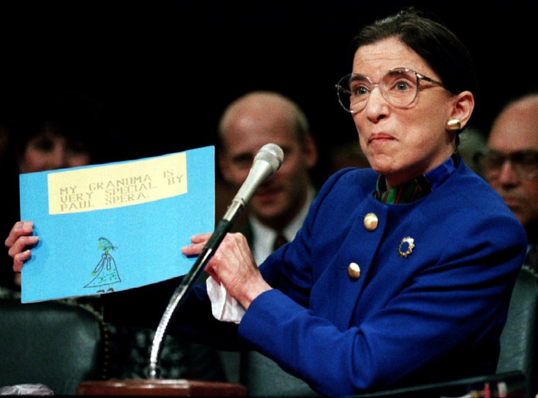 Image: US Supreme Court nominee Ruth Bader Ginsburgh holds up a drawing of herself with the words \"My Grand..