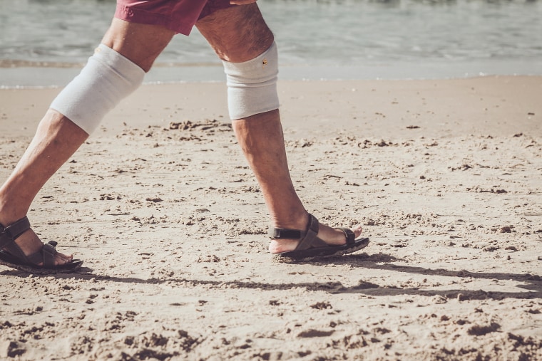 Active senior walking on the sandy beach