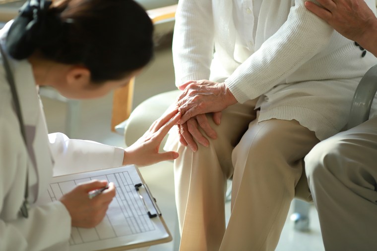 Doctor checking patient's knee pain