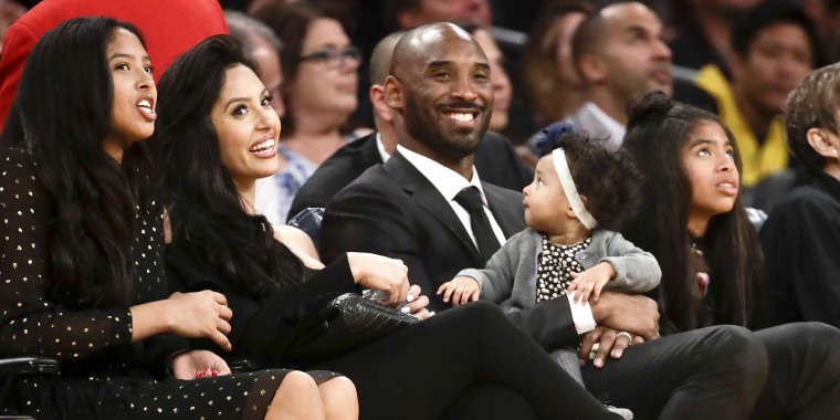 Former Los Angeles Laker Kobe Bryant watches a tribute video with his family during an NBA basketball game between the Los Angeles Lakers and the Golden State Warriors in Los Angeles on Dec. 18, 2017.