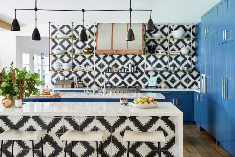 The kitchen features funky black-and-white tiles and a bold pop of blue. 