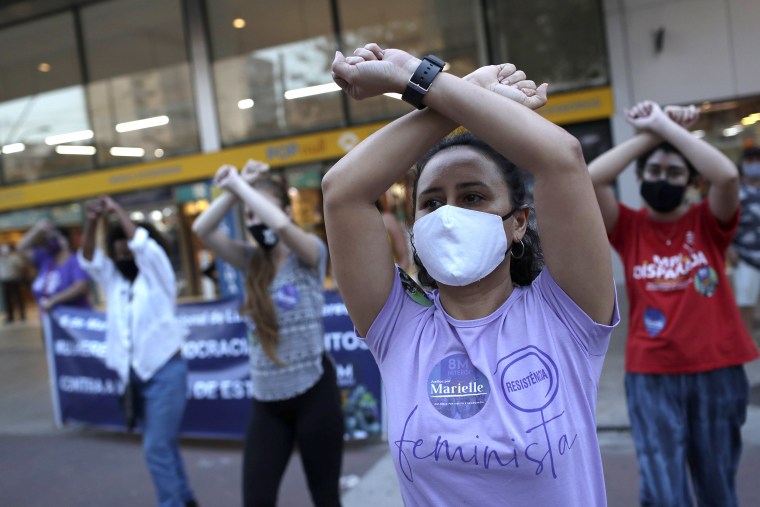 Image: Women wearing masks to curb the spread of the new coronavirus, participate in "The rapist is you," a feminist performance piece originating in Chile to protest violence against women, during a demonstration against rape, gender-based violence, and