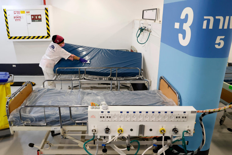 Image: A worker cleans a bed mattress in an underground parking lot that has been transformed into an intensive care facility for coronavirus patients in the Israeli city of Haifa.