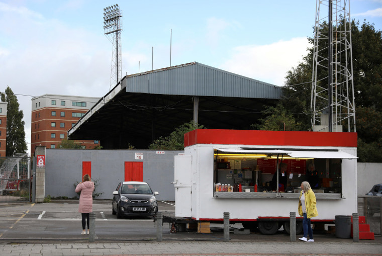 Image: Women wait at a mobile sandwich bar outside The Racecourse stadium, the home of Wrexham Football Club, in Wrexham, Britain