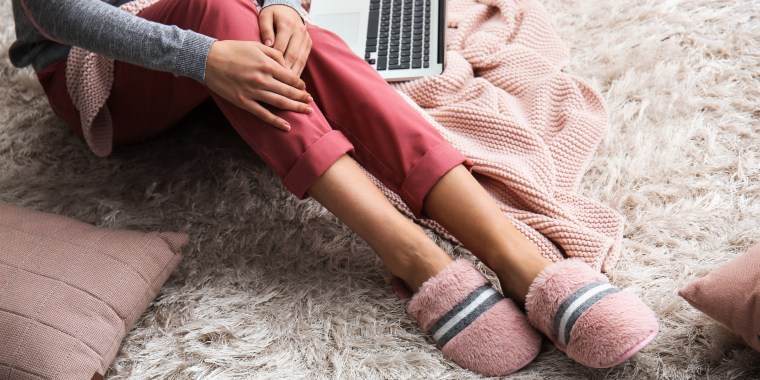 woman wearing slippers working from home on laptop